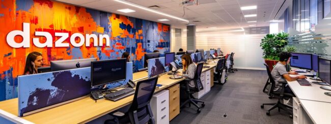 a modern call center office features sleek workstations and a bold mural of the word "dazonn" on the walls, capturing the dynamic interaction between live chat agents and advanced chatbots in a bustling business environment.