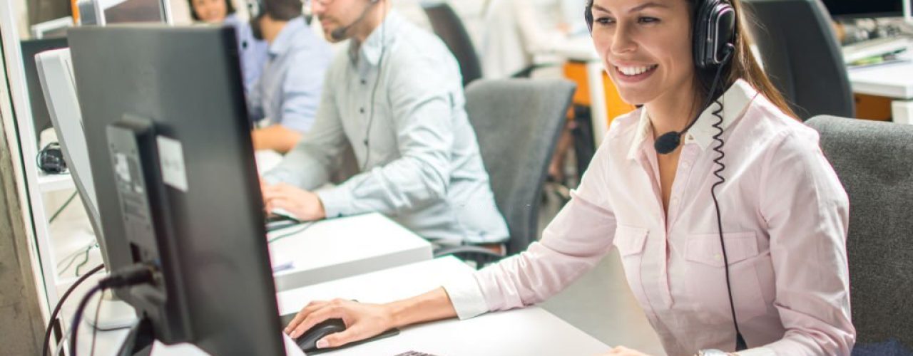 Woman using a headset at a computer in an outbound call center, demonstrating Dazonn Assist's dedicated agent model for effective customer engagement and lead generation.